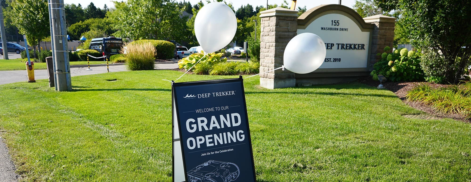 image of lawn sign that says grand opening with balloons, for the deep trekker hq grand opening.